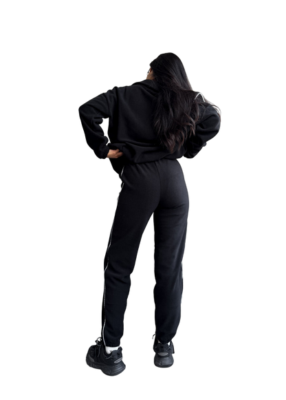 Person wearing a black tracksuit on a white background