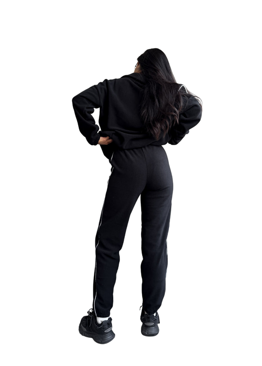 Person wearing a black tracksuit on a white background