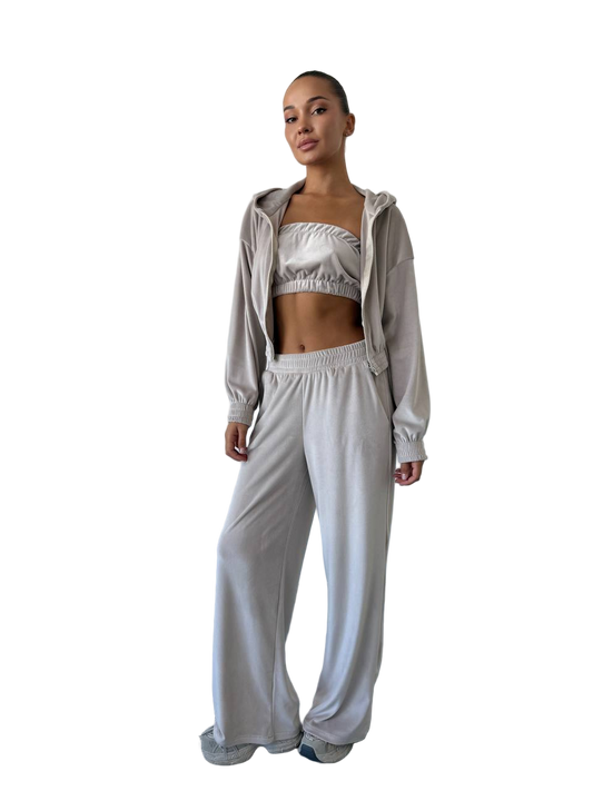 Woman wearing a light gray tracksuit on a white background