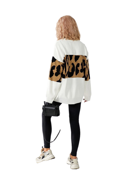 Person wearing a white sweater with leopard print sleeves on a white background