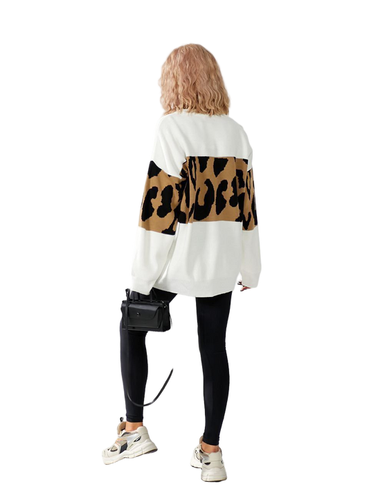 Person wearing a white sweater with leopard print sleeves on a white background