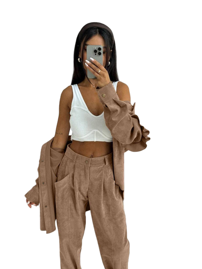 Person wearing a white top and brown pants with a matching jacket on a white background