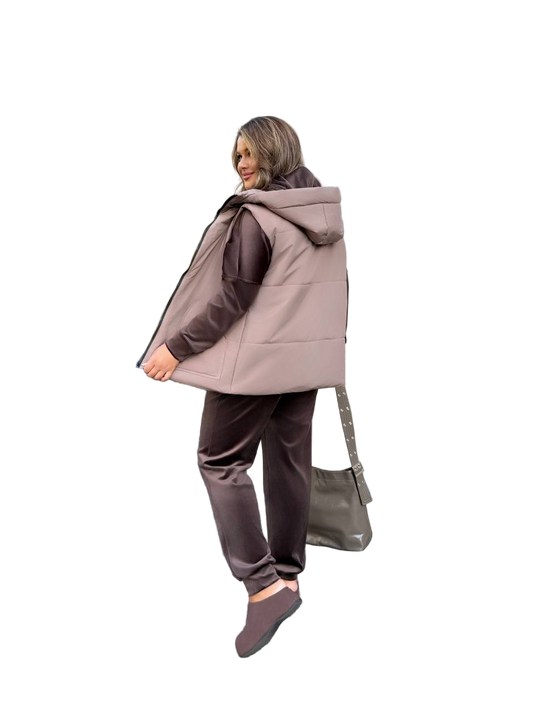 Woman wearing a beige hooded jacket and brown pants on a white background