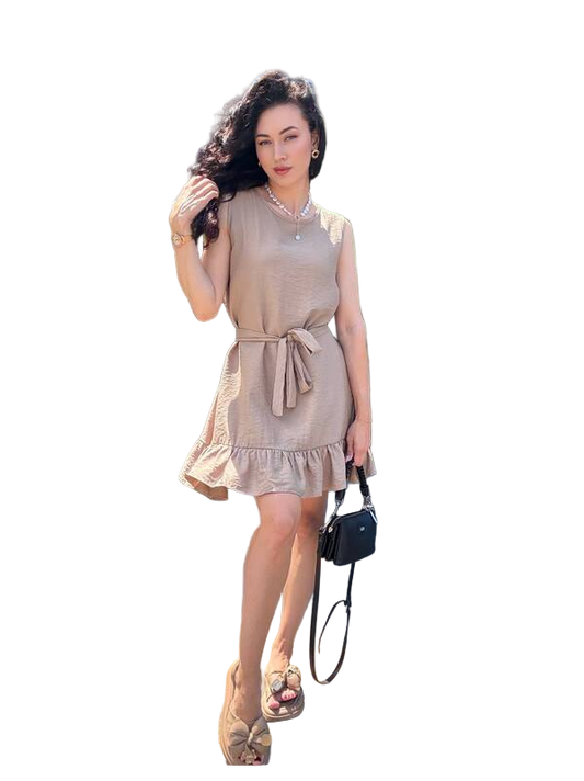 Woman wearing a beige dress holding a black handbag on a white background