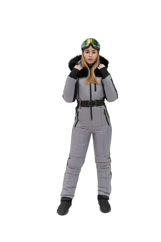 Person wearing a gray snowsuit with black boots and a helmet on a white background