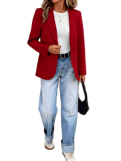 Person wearing a red blazer, white shirt, and blue jeans with a black handbag.