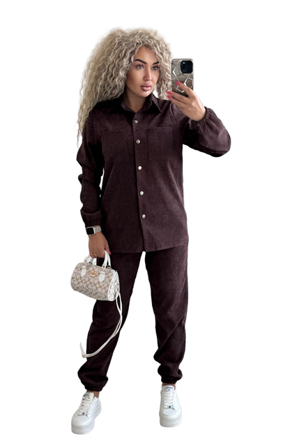 Woman taking a selfie wearing a brown corduroy outfit with a white background