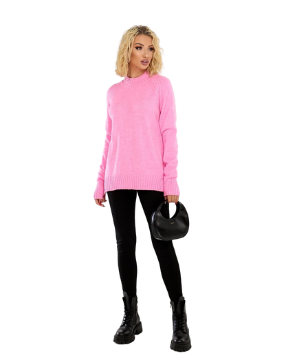 Woman wearing a pink sweater and black pants on a white background