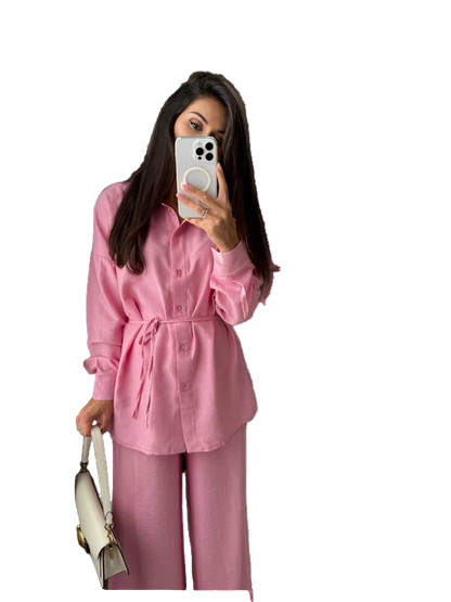 Person wearing a pink outfit taking a mirror selfie.