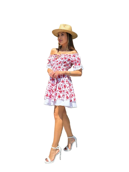 Woman wearing a floral off-shoulder dress and straw hat on a white background